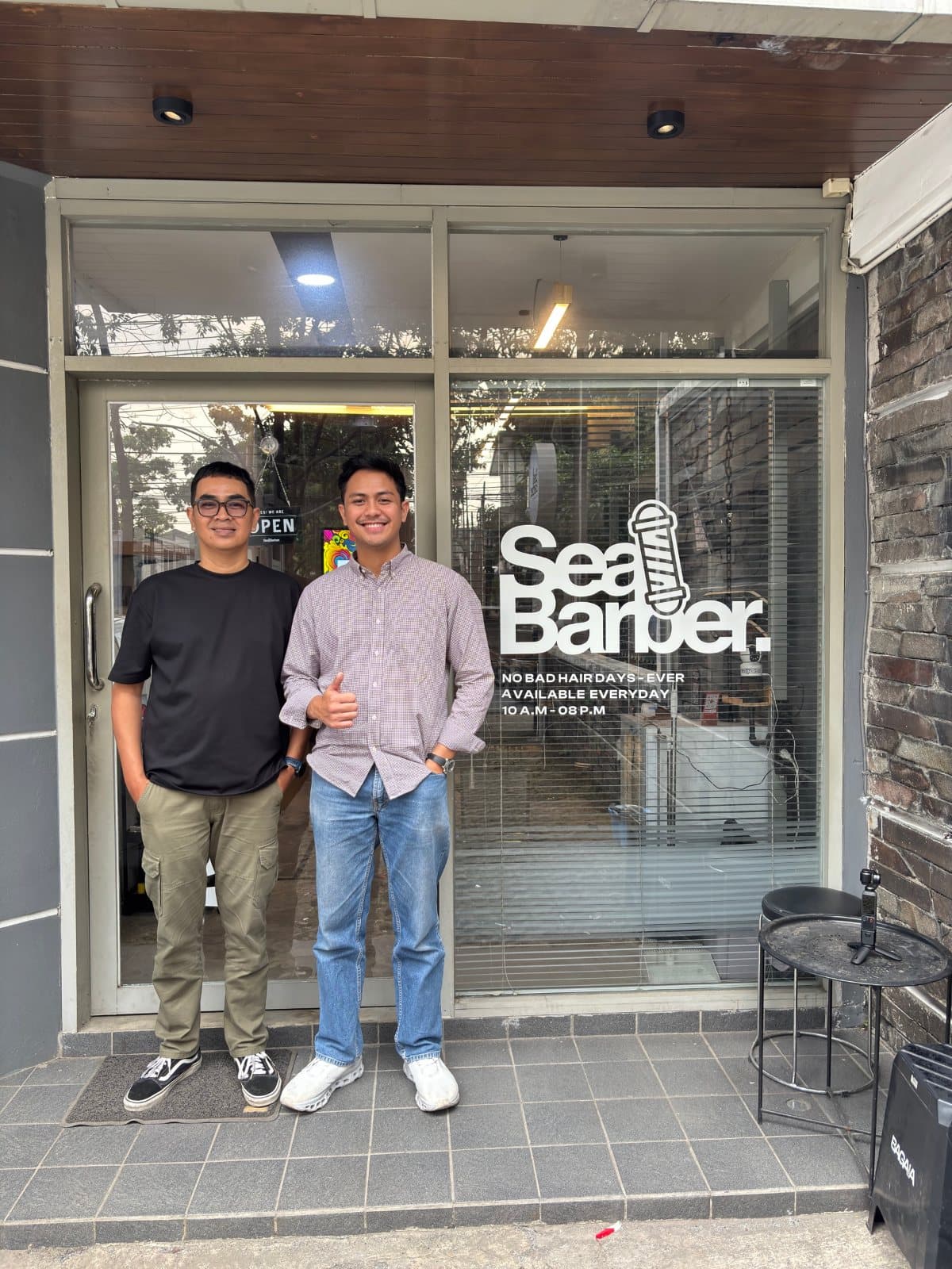 Dua anggota tim SeaBarber berdiri di depan gerai